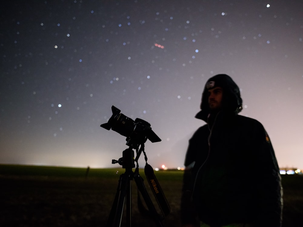 A telescope pointed at a star field above desert scrub.