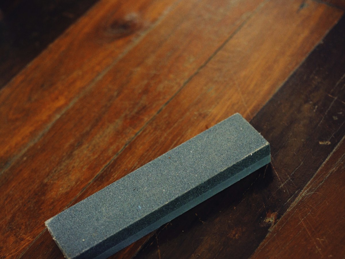 A sharpening stone on a wooden bench.