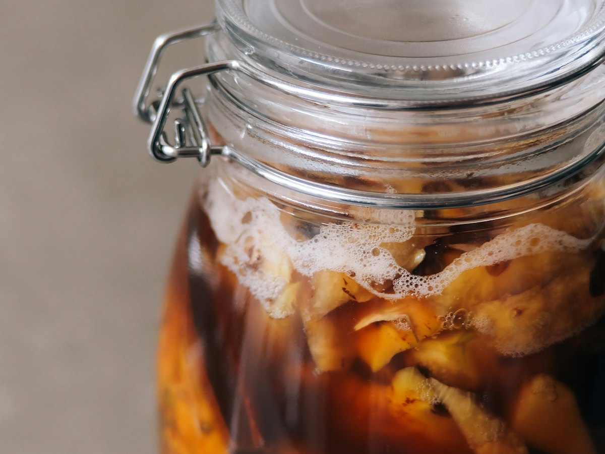 Fruit fermenting in a glass jar with a clip lid.