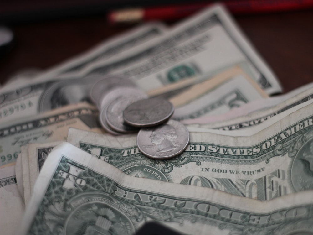 Historic banknotes and coins laid out on a dark table.