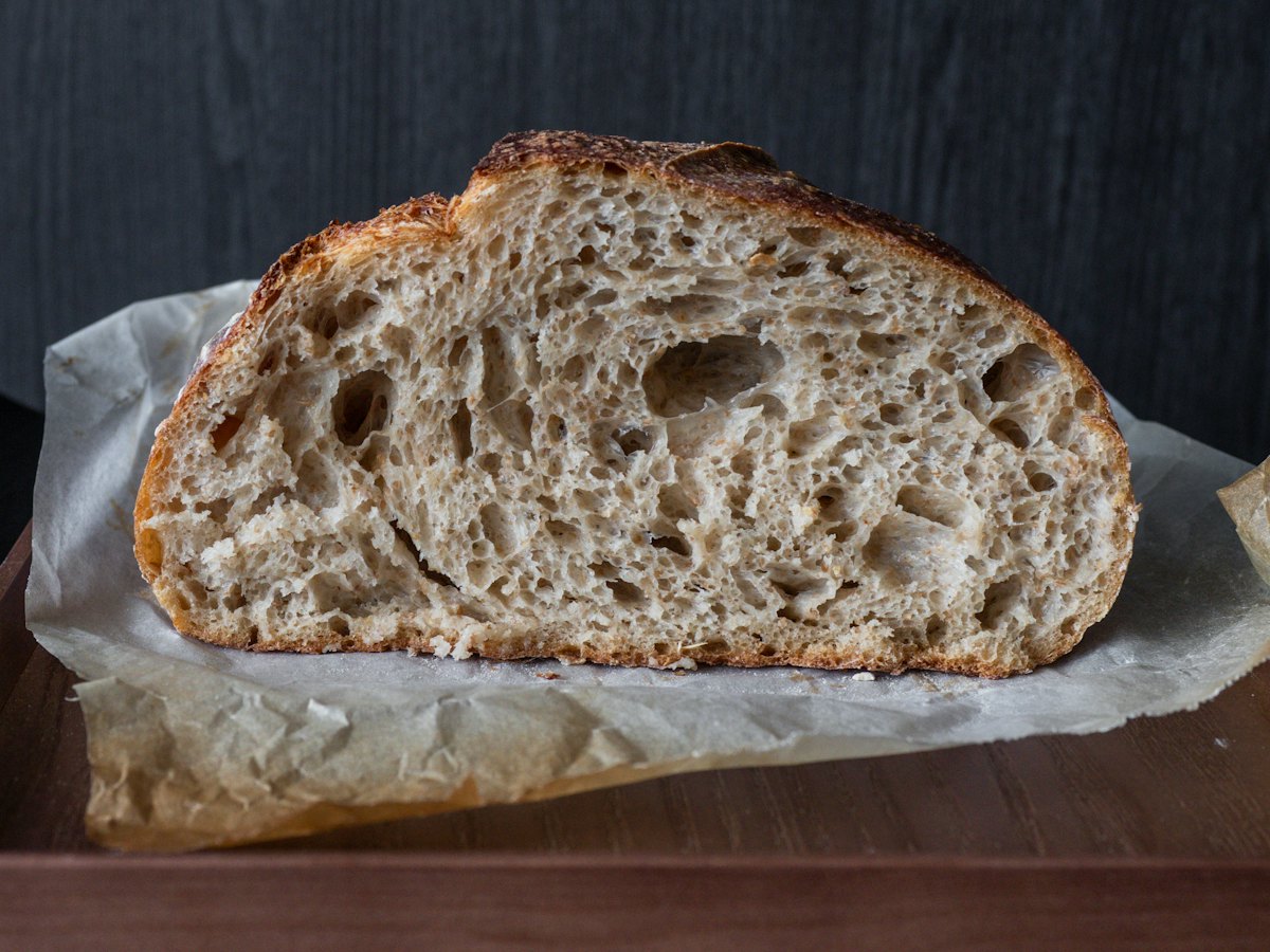 A sourdough loaf cut open to show its open crumb.