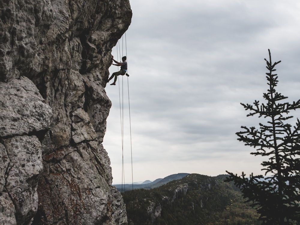 A climber on granite with a belayer holding the rope below.