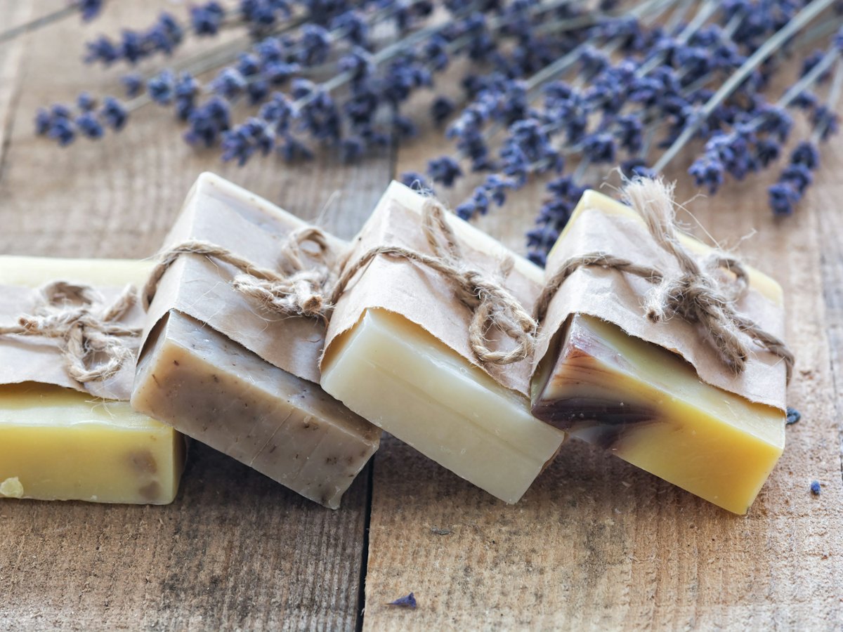 Bars of handmade soap tied with string beside lavender.