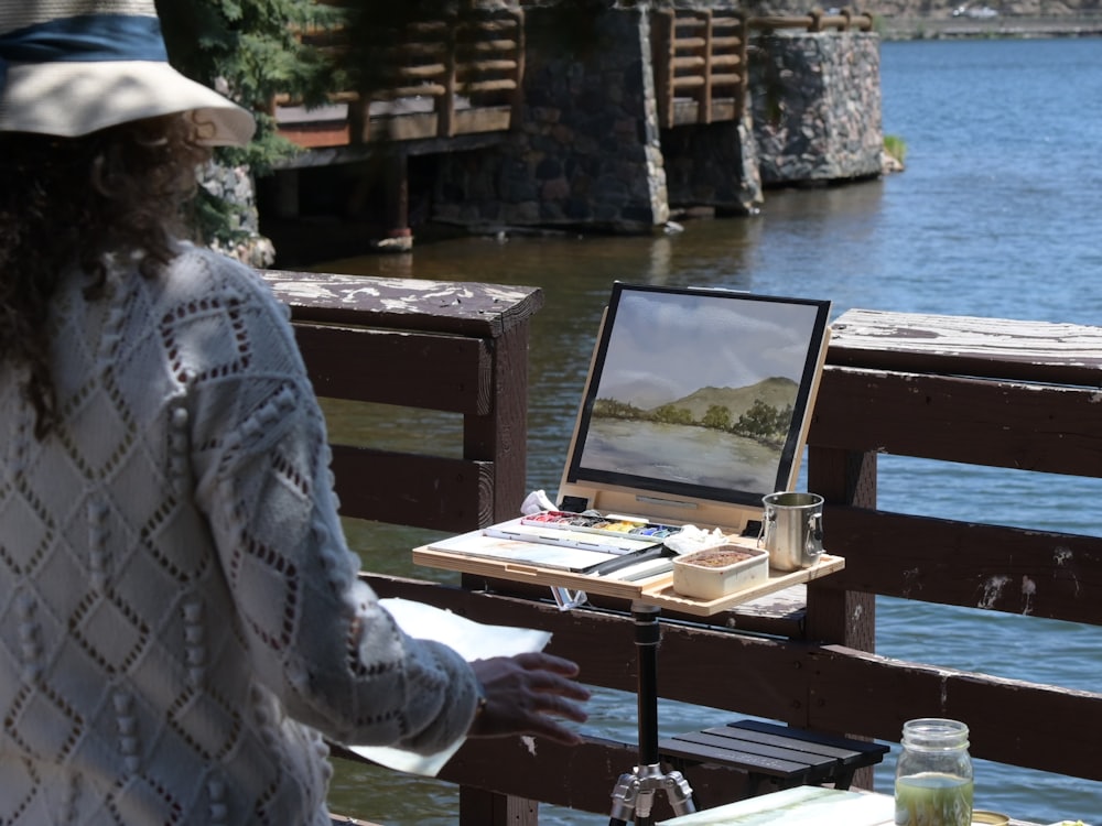 A field easel and watercolour box open on a coastal bluff.