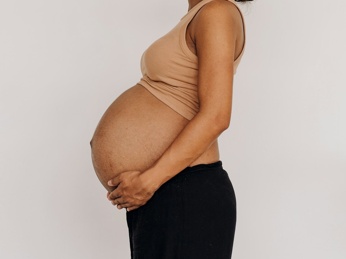 A pregnant woman standing in profile.