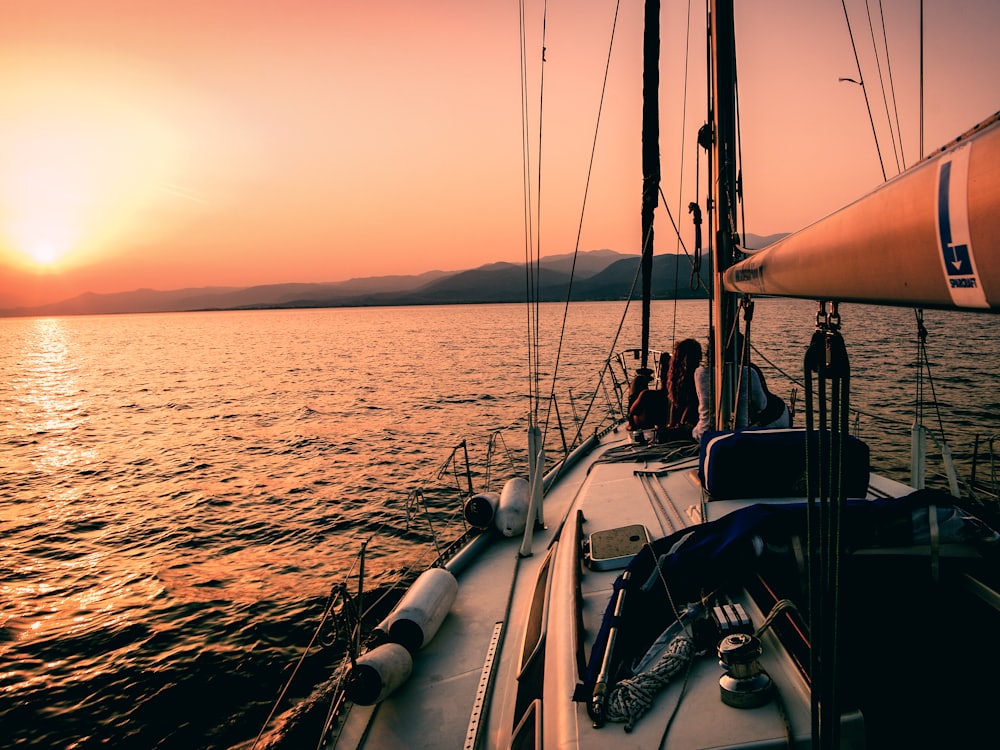 A sailing boat heeled over in evening light on the bay.