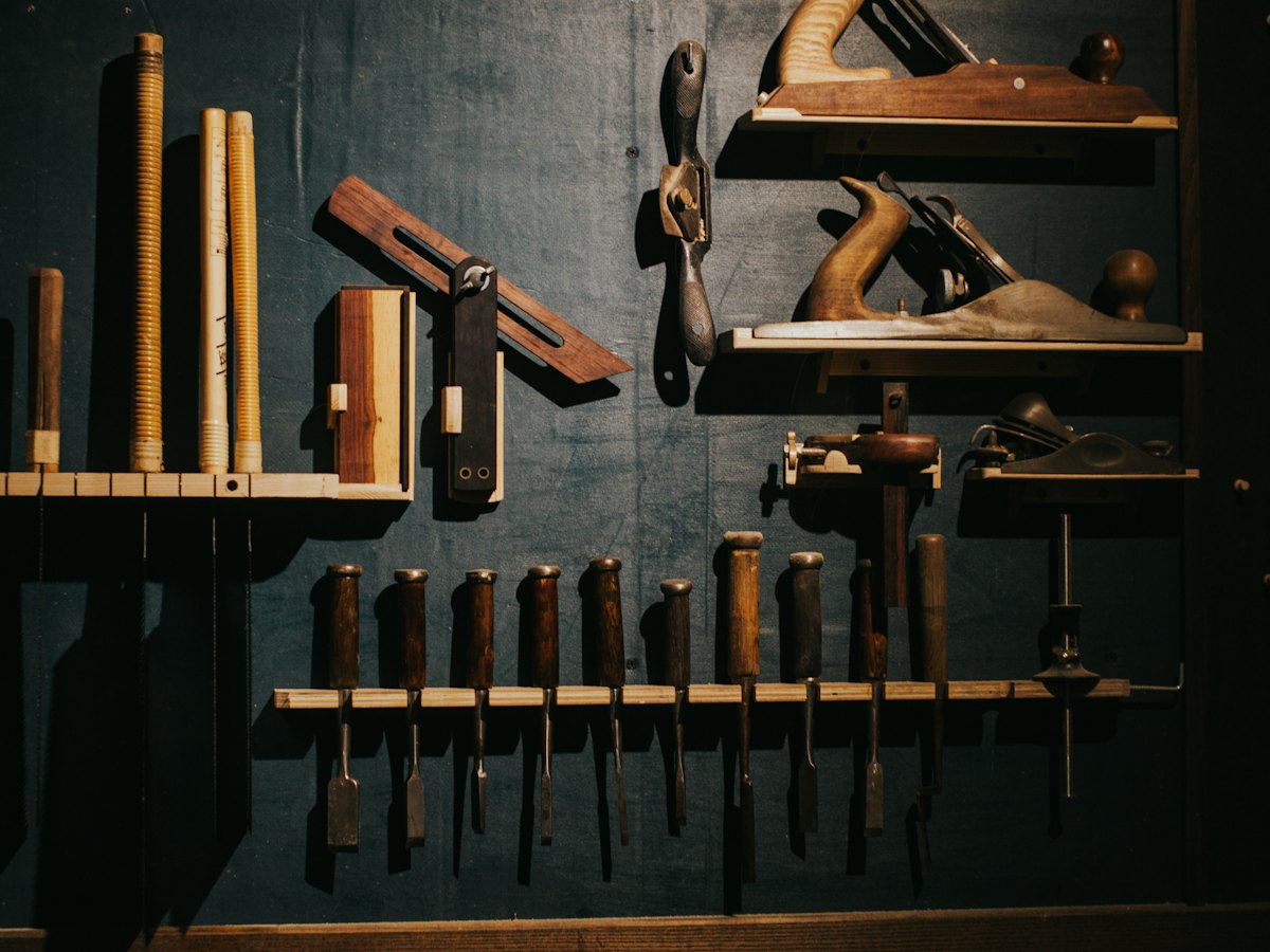 Hand planes and chisels hanging on a workshop wall.